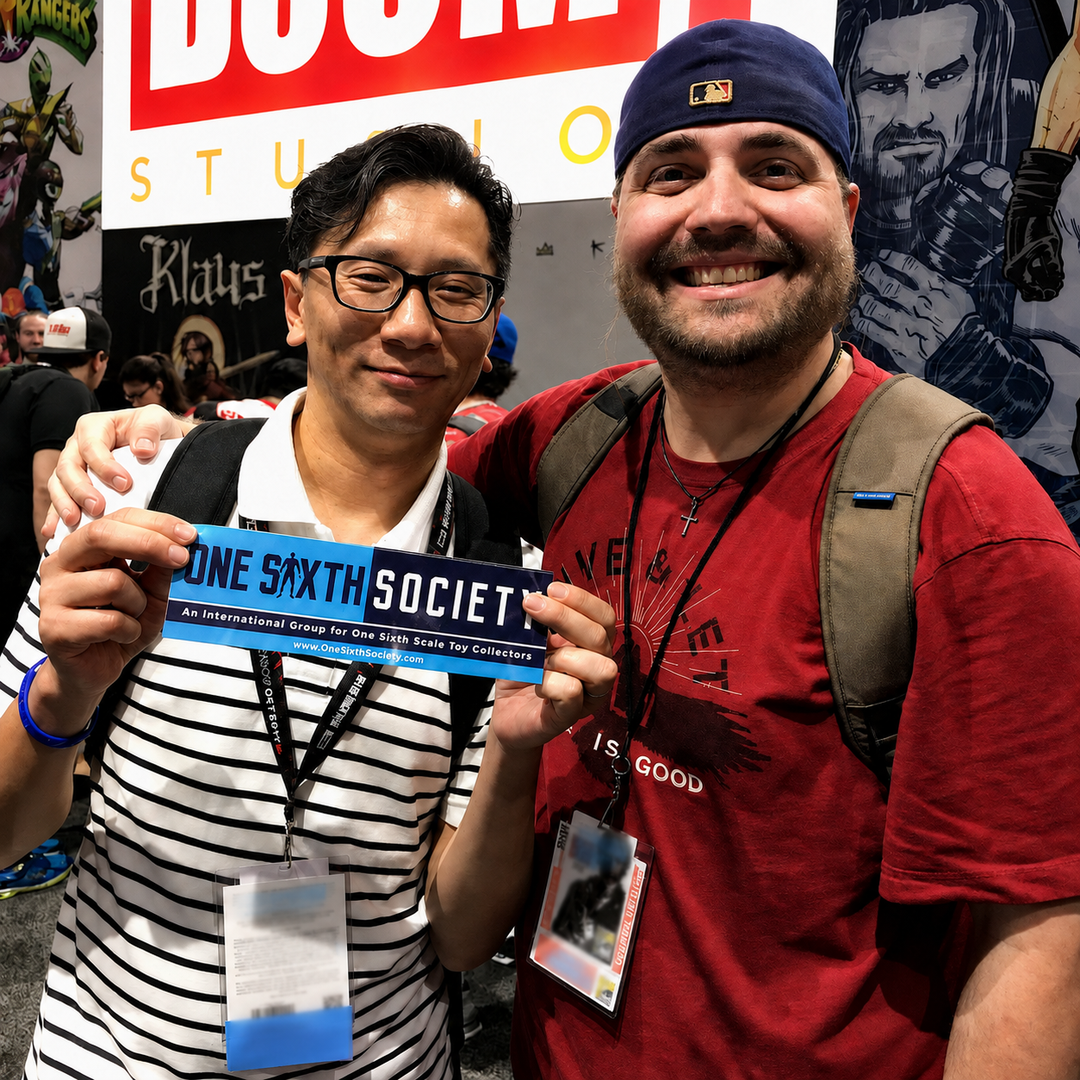 Two collectors holding a One Sixth Society sign at a collectibles event