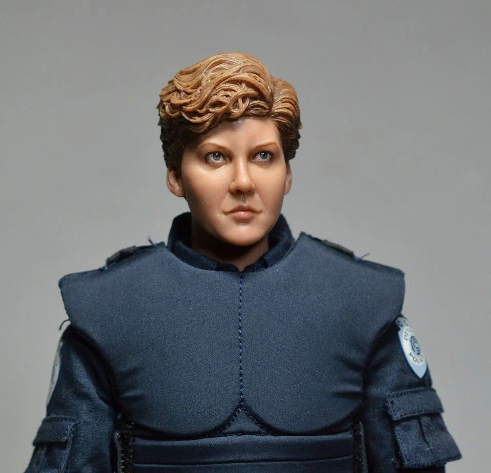 Front portrait of the custom Anne Lewis figure showing short sculpted hair, painted eyes and padded police shoulder armor.