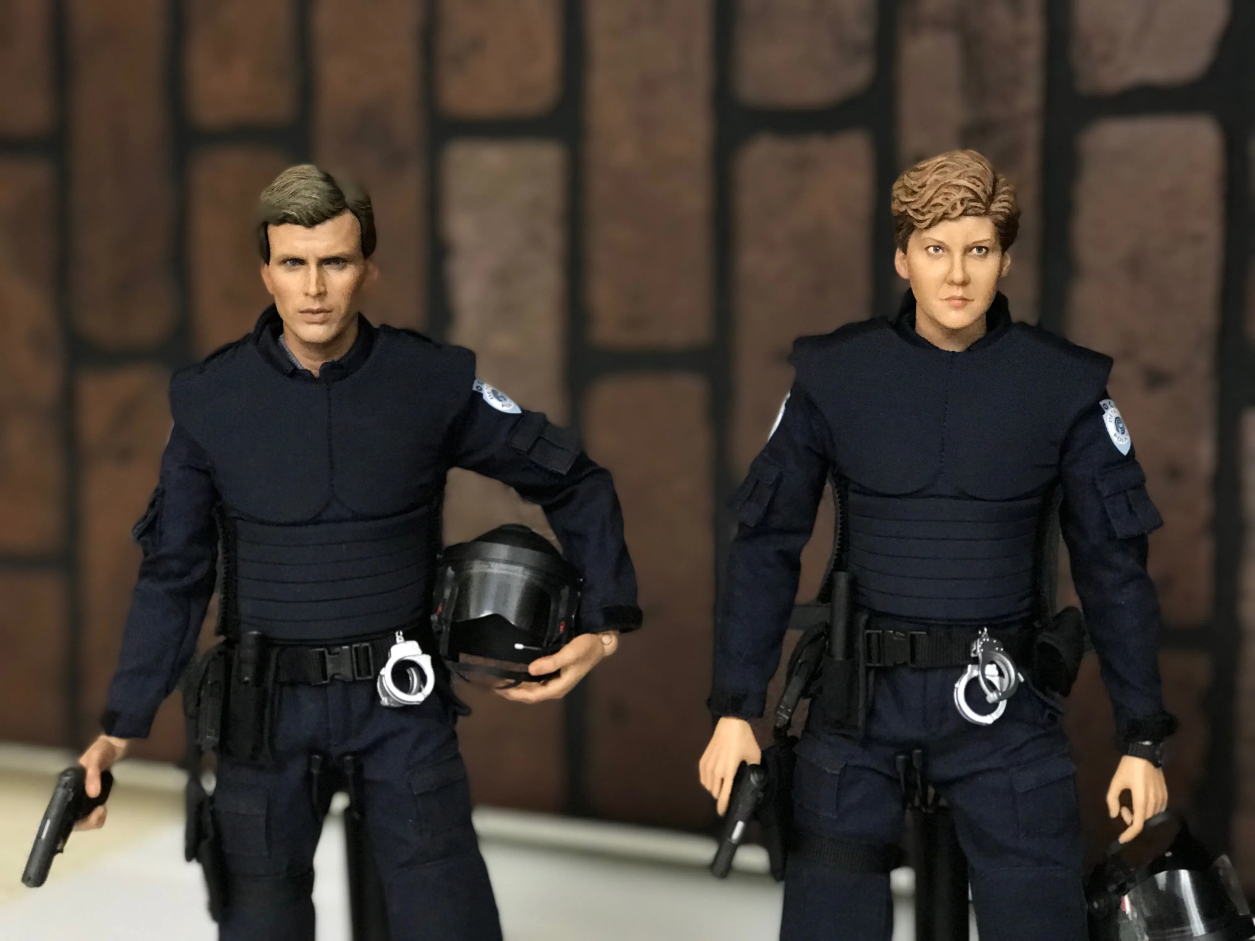 Custom Anne Lewis and Alex Murphy figures standing side by side in dark police uniforms with helmets and handguns.