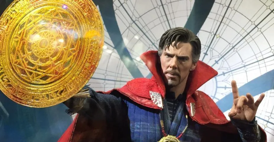 Hot Toys Doctor Strange in a blue costume and red cloak, extending a large golden circular spell effect beside a raised gesturing hand.