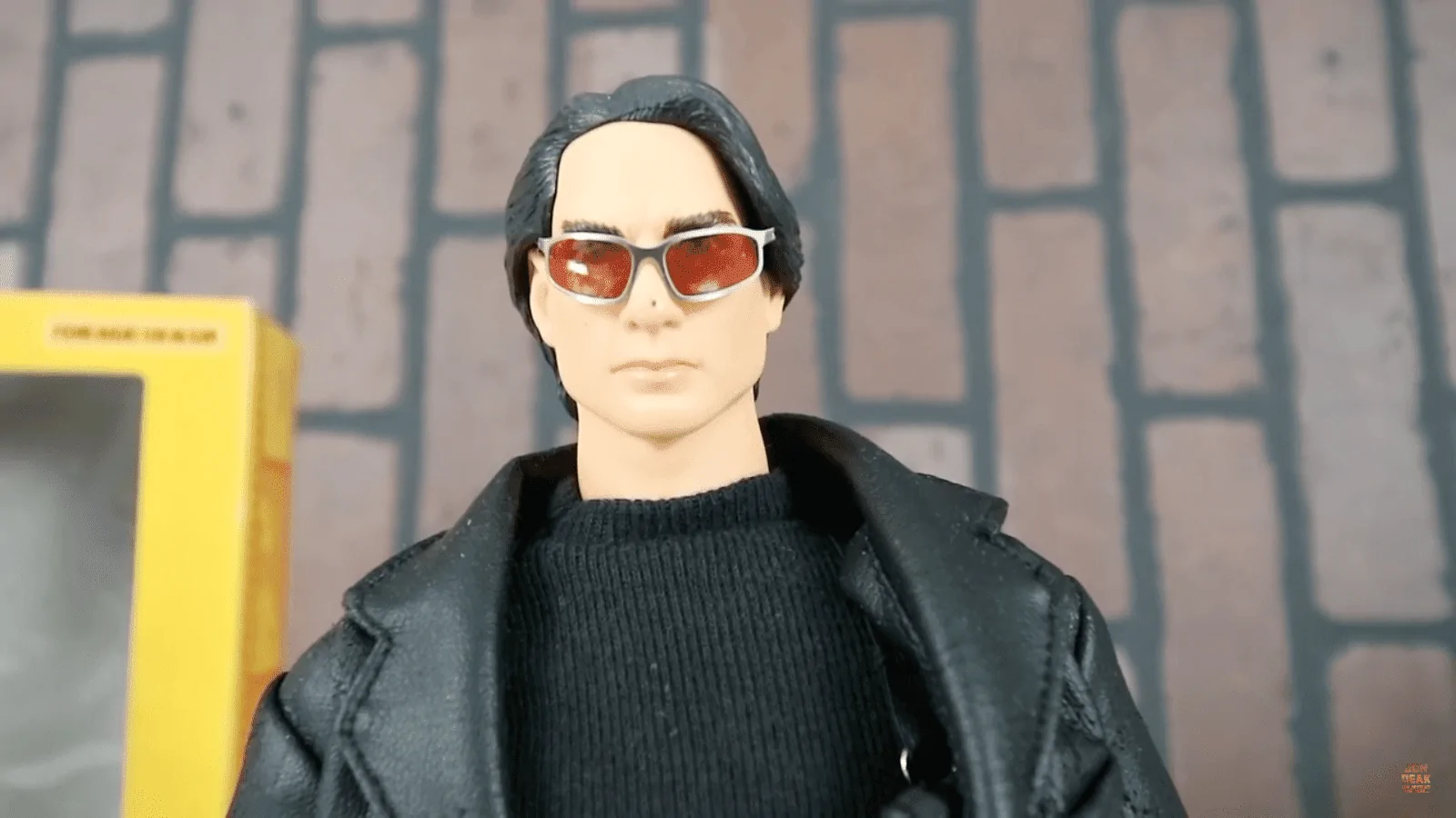 Close-up of the early Hot Toys Ethan Hunt figure’s swept-back black hair, red-lensed sunglasses, black shirt and jacket collar.