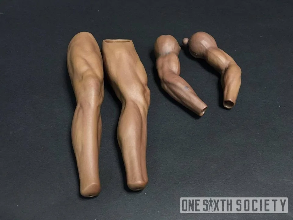 Two detached figure legs and two bent arms arranged on a dark surface, illustrating the Mike Tyson limb-replacement discussion.
