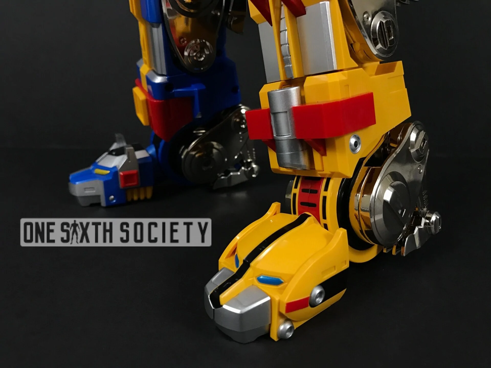 Close-up of Voltron GX-71's yellow and blue lion legs, showing silver-colored wheel details, red joints and the lion-head feet.