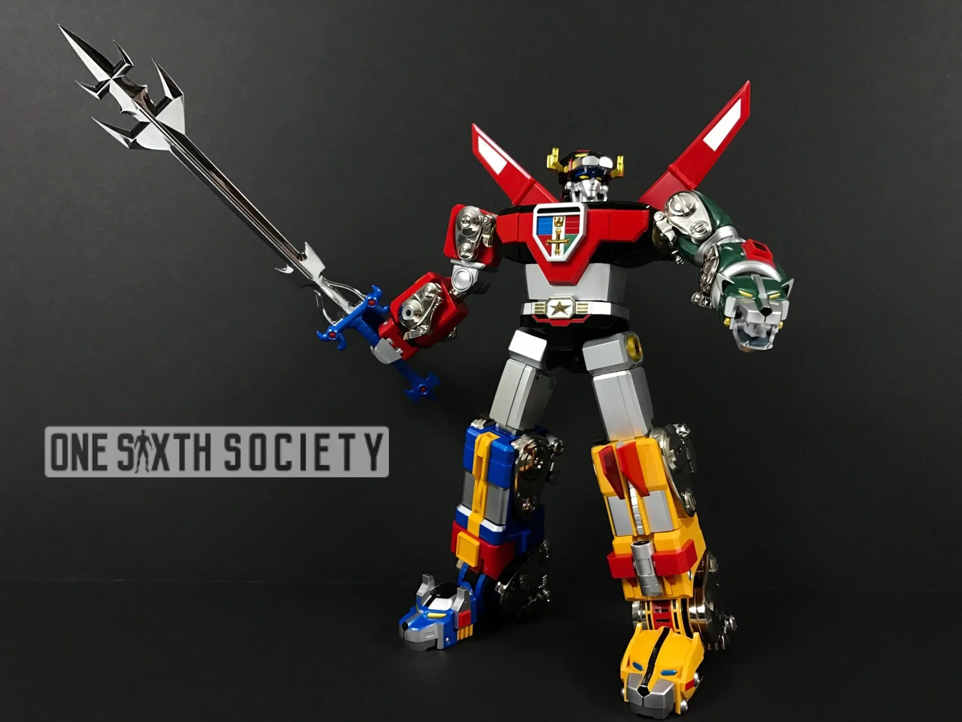 Fully assembled Voltron GX-71 with red shoulder fins, yellow-and-blue lion legs and a long silver-colored sword held diagonally upward.