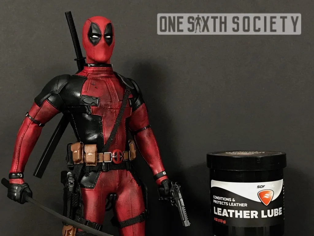 Deadpool figure holding a pistol beside a black container labelled Leather Lube.
