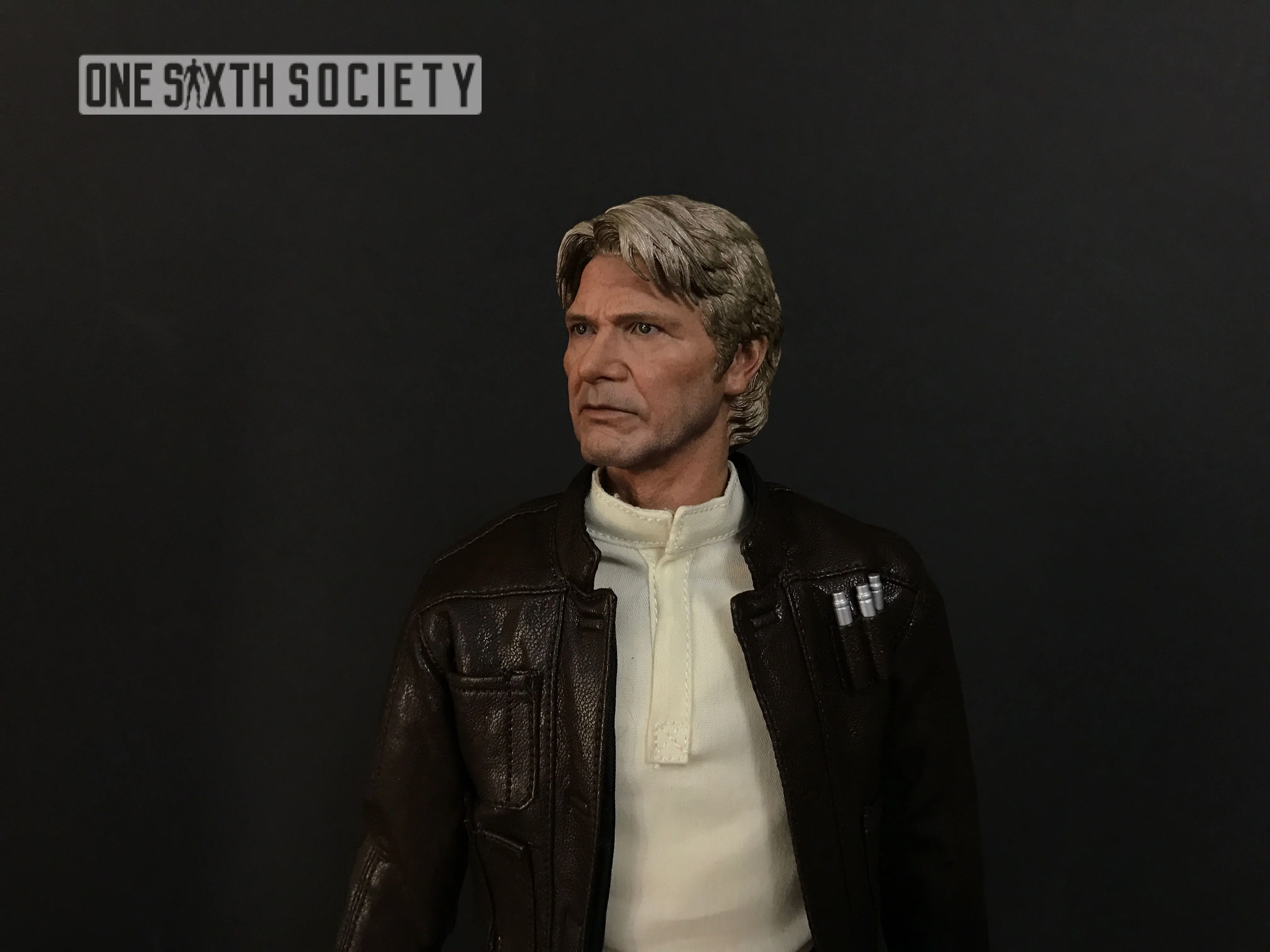 Three-quarter close-up of the older Han Solo head sculpt with gray hair and facial wrinkles above a brown jacket and cream shirt.
