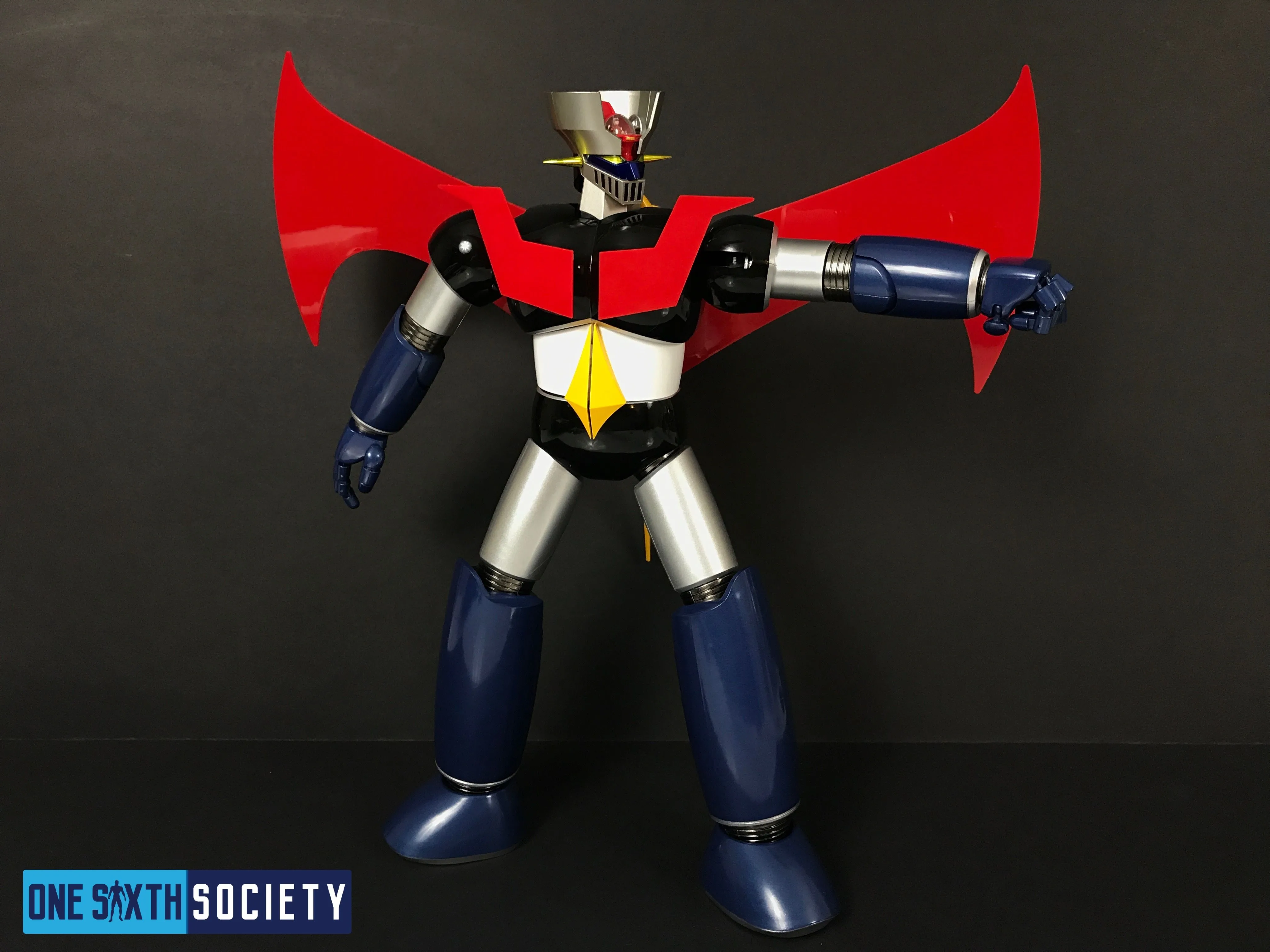 Future Quest Mazinger Z extending one blue forearm straight out to the side, with its red chest panels and Scrander wings visible.