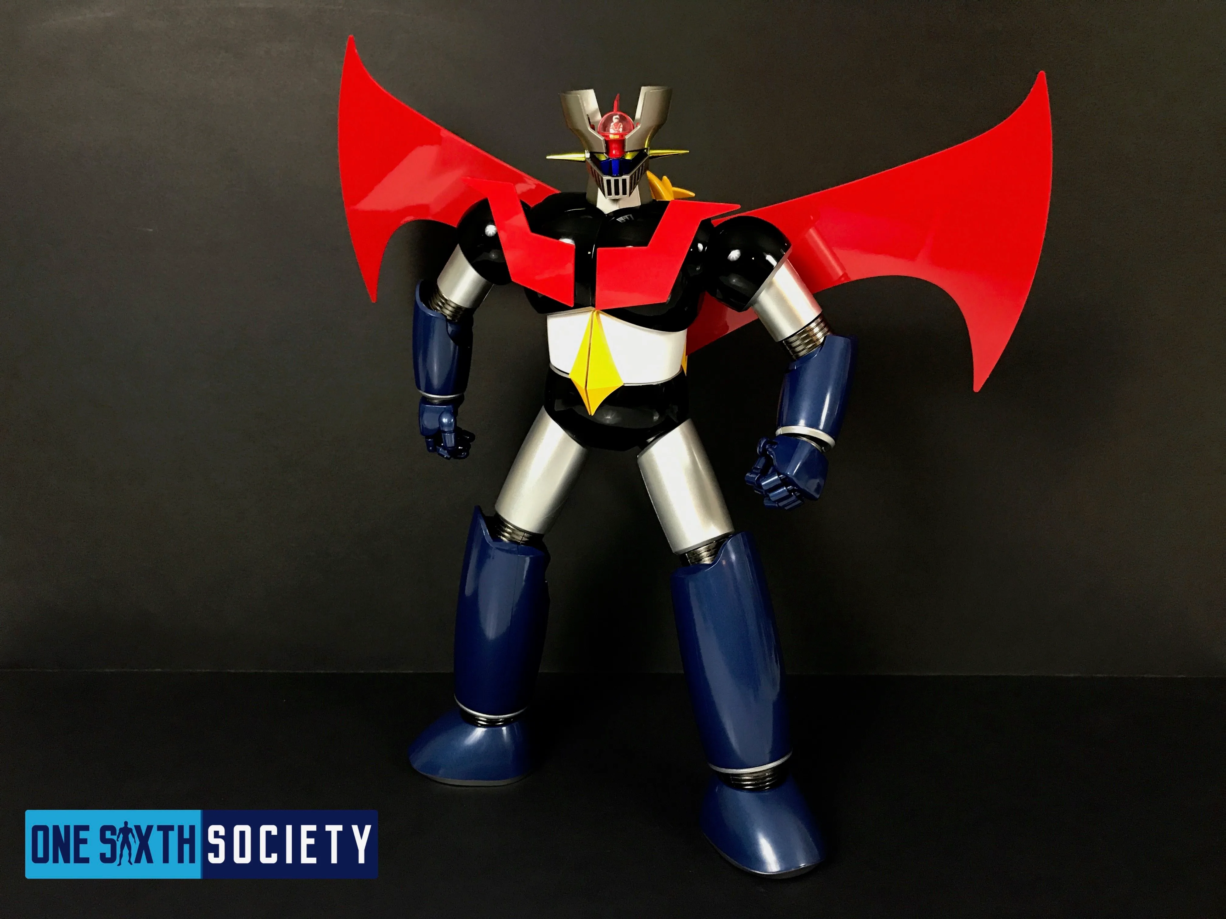 Full-length Future Quest Mazinger Z in a wide-legged stance, with both fists lowered and large red Scrander wings attached.