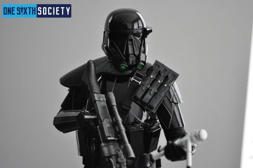 Close-up of the Death Trooper's glossy black helmet and armor, green helmet details, specialist chest equipment and blaster.