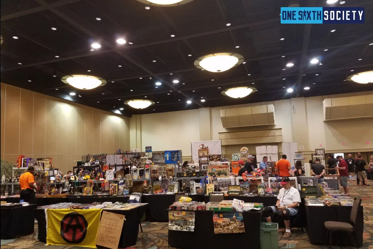 Wide view of the JoeCon 2017 dealer hall, with tables of boxed figures and collectibles beneath the ballroom lights.
