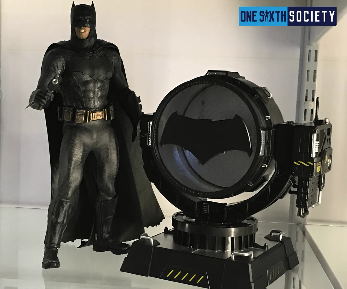 Broad-shouldered armored Batman figure standing beside an unlit Hero Club spotlight fitted with a wide bat-shaped emblem.