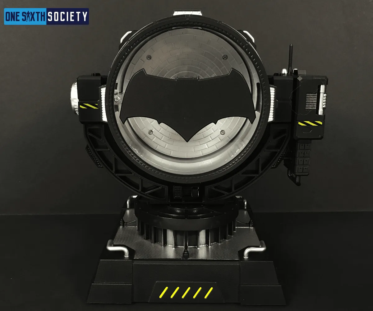 Front view of the unlit Hero Club Bat Spotlight, with a wide black bat emblem across its circular lens and yellow warning stripes on the stand.