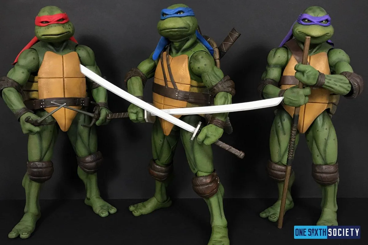 NECA movie Raphael, Leonardo and Donatello figures standing together with sai, paired swords and a bo staff.