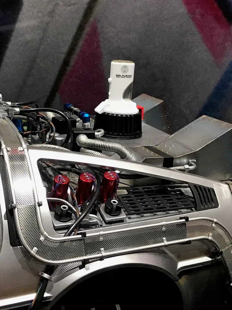 Hot Toys DeLorean rear-deck close-up with the white Mr. Fusion unit, exposed cables, red components and silver bodywork.