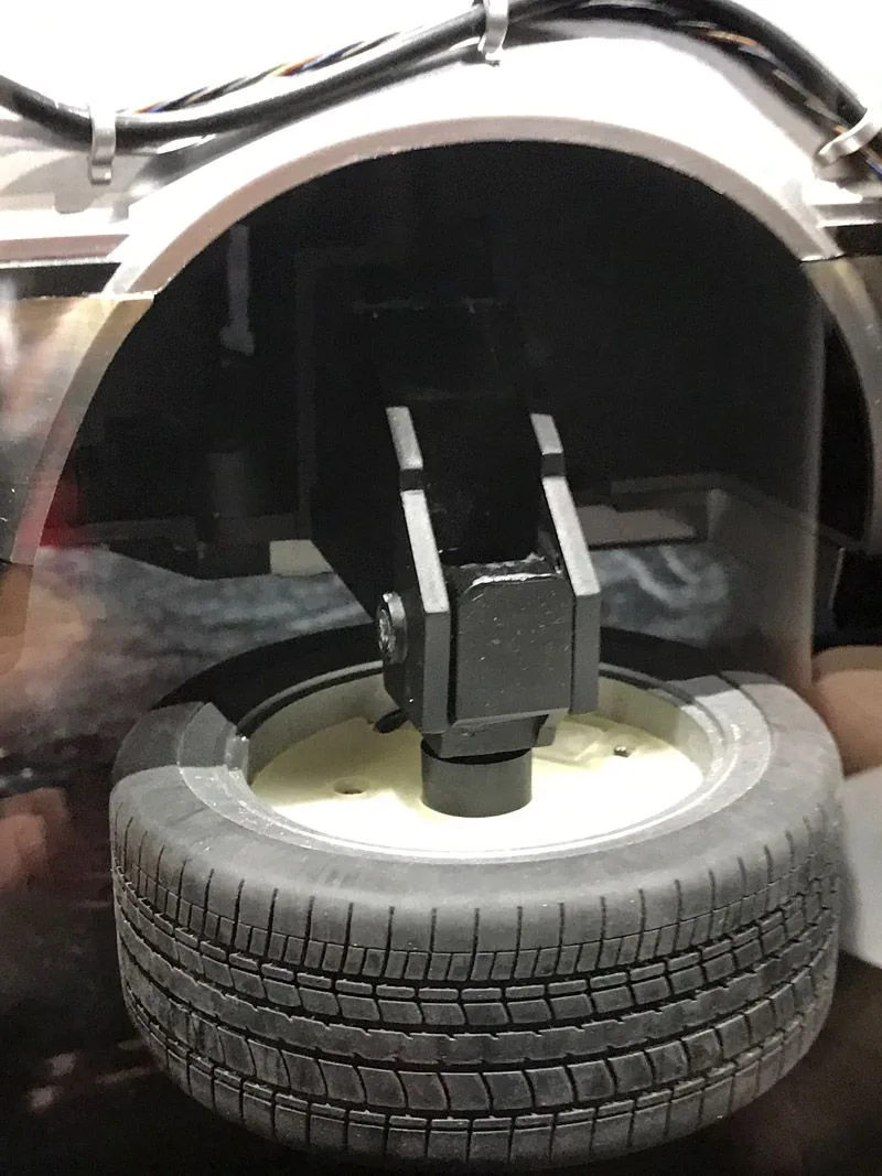 Close-up of a Hot Toys DeLorean wheel rotated horizontally beneath its open wheel arch for the flight configuration.