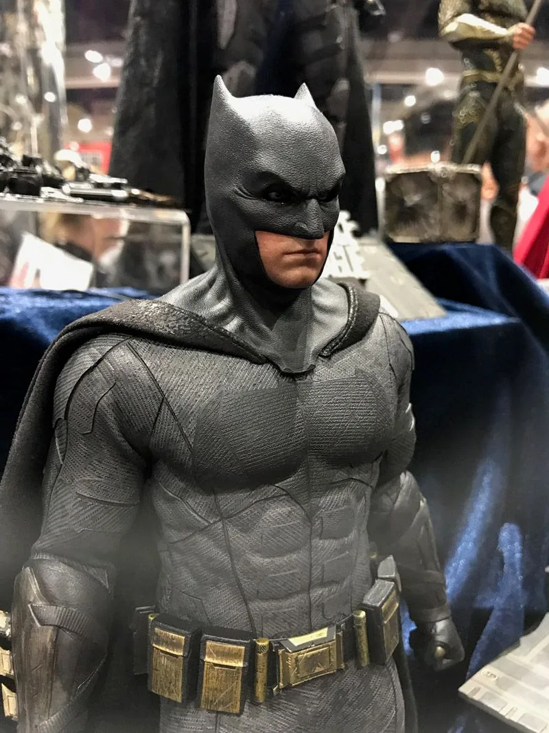 Close-up of Hot Toys Batman in a textured gray suit, showing the black cowl, broad chest emblem and gold utility belt.