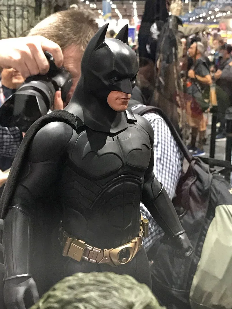 Hot Toys Batman in a black cowl and sculpted chest armor, shown from the waist up with a gold utility belt.