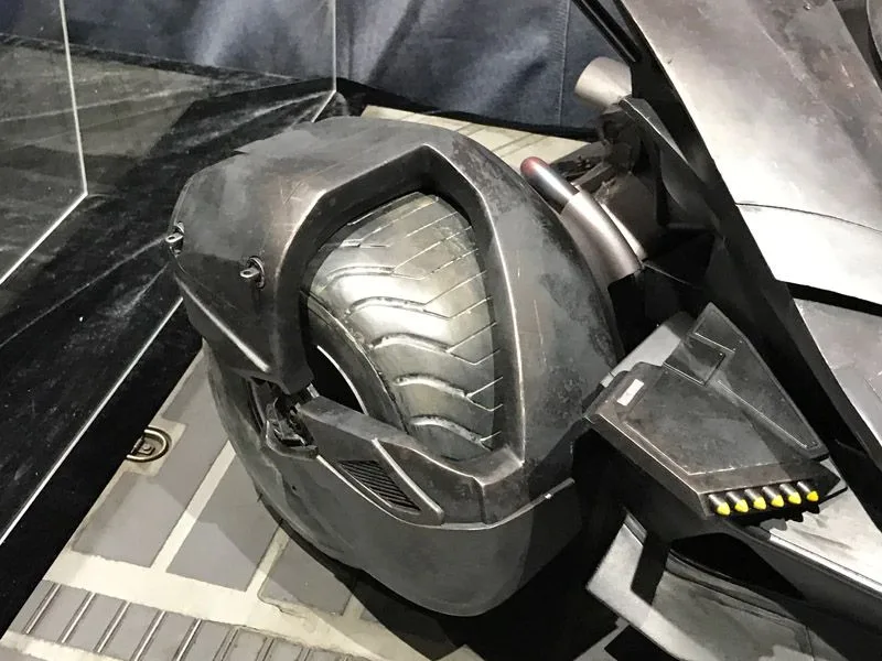 Close-up of a Hot Toys Batmobile tire enclosed by angular gray bodywork, beside a small row of yellow-tipped details.