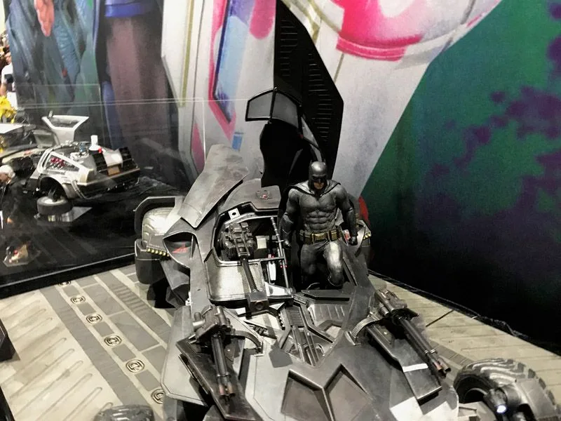Hot Toys Batmobile viewed from above at an angle, showing its raised black cockpit panels and a Batman figure beside the opening.