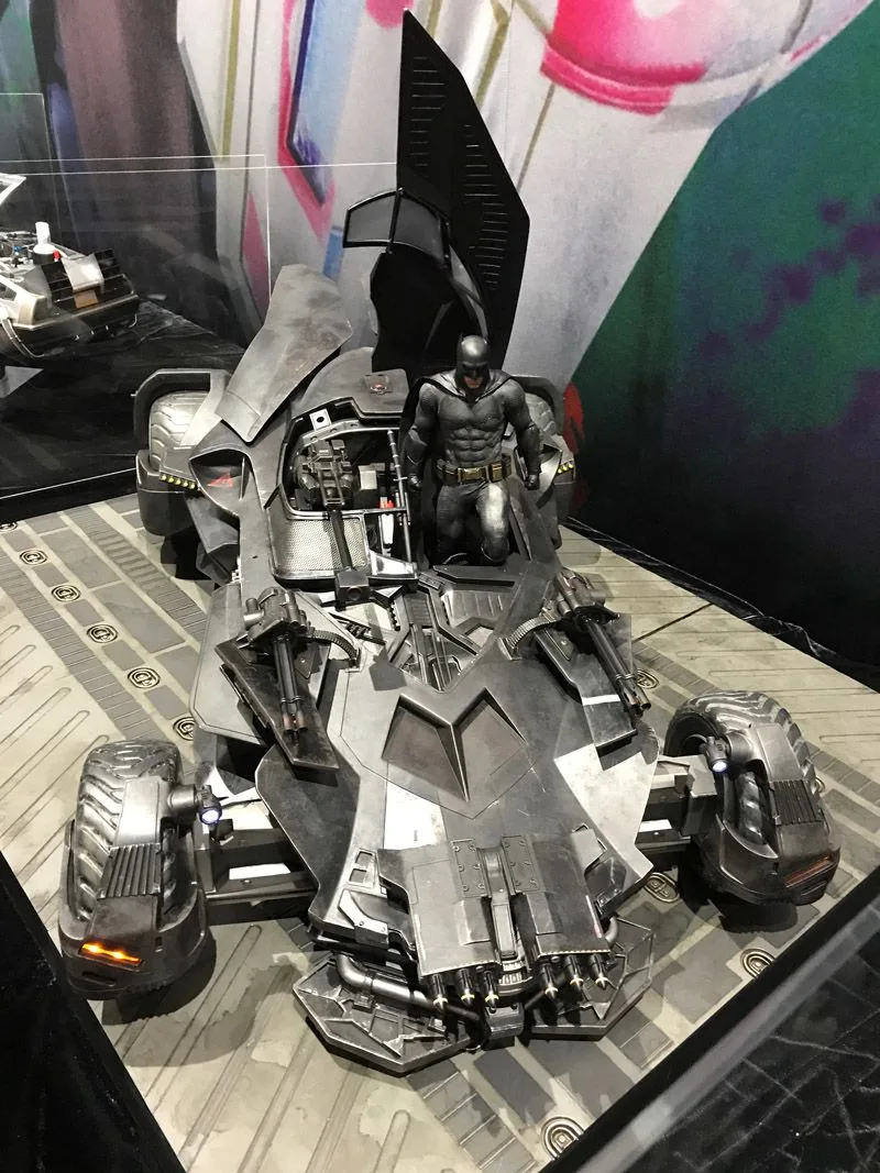 Overhead front view of the Hot Toys Batmobile with raised cockpit panels, front-mounted weapons and Batman crouching beside the open seat.