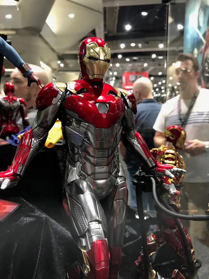 Hot Toys Iron Man figure with red helmet and shoulder plates, silver torso armor and open hands in the Comic-Con display.