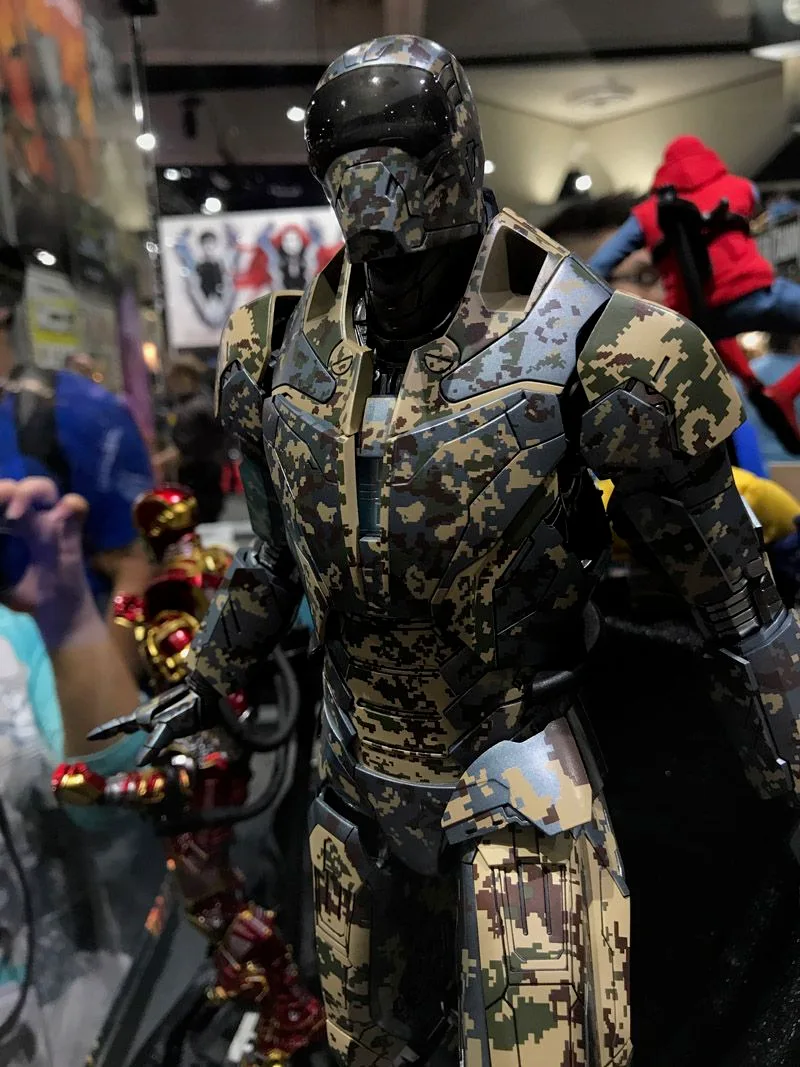 Hot Toys Iron Man upper-body view showing a dark helmet and tan, gray and olive digital-camouflage armor.