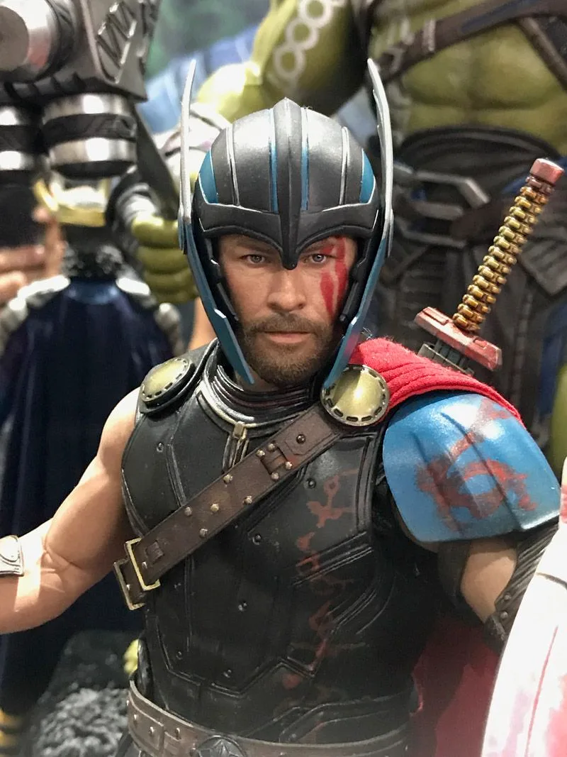 Hot Toys Gladiator Thor wearing a blue-striped helmet, blue shoulder armor and red face paint, with short hair and a beard.