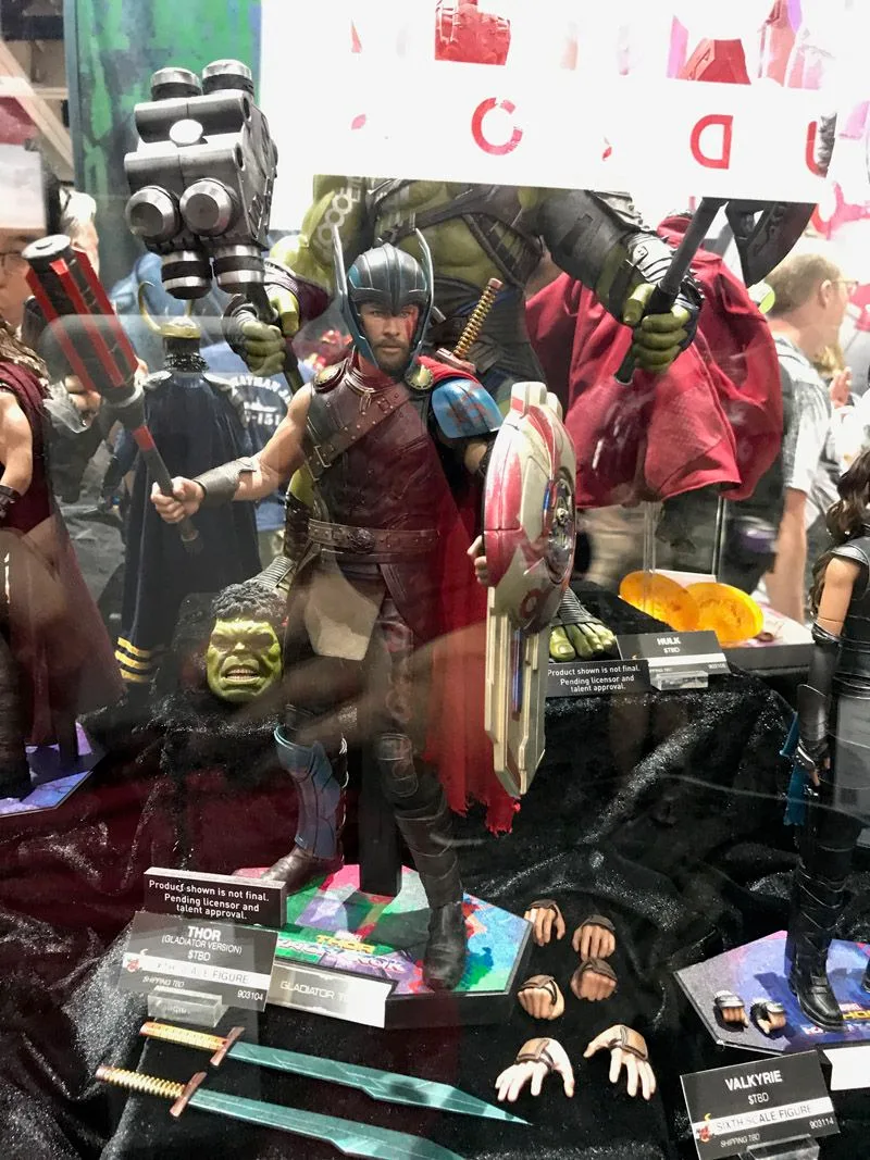 Hot Toys Gladiator Thor holding a weapon and painted round shield, with swords, alternate hands and a head sculpt displayed below.
