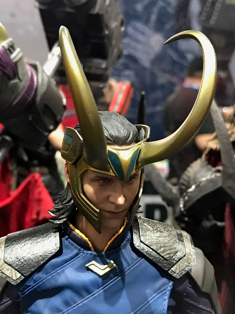 Hot Toys Loki portrait showing a blue outfit, textured shoulder pieces and a gold helmet with long curved horns.