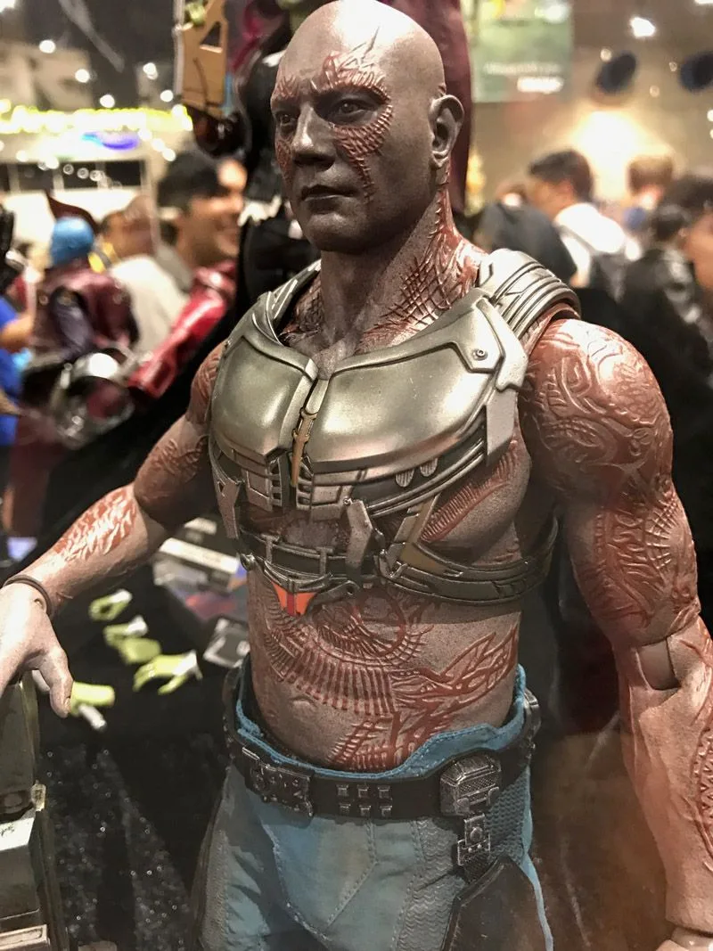 Hot Toys Drax upper-body view showing red textured tattoos, a gray chest harness and blue trousers.