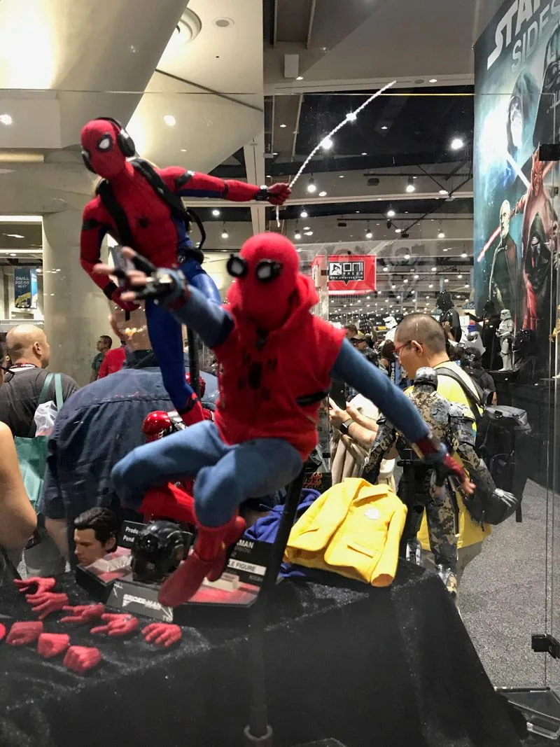 Hot Toys Spider-Man in a red hooded homemade suit and blue trousers reaching forward, with another Spider-Man posed behind him.