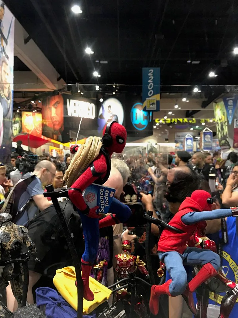 Hot Toys Spider-Man in his red-and-blue suit with a tan backpack, perched beside the homemade-suit Spider-Man figure.