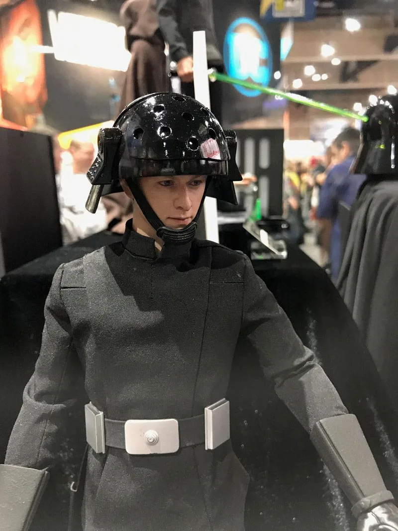 Hot Toys Death Star Trooper close-up showing a broad glossy black helmet, dark uniform, white belt and black gloves.