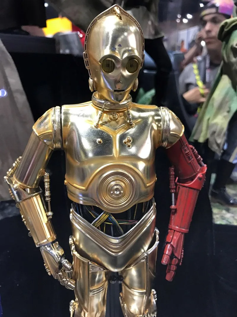 Hot Toys C-3PO close-up showing gold head and chest plates, a red left arm and multicolored wiring across the waist.