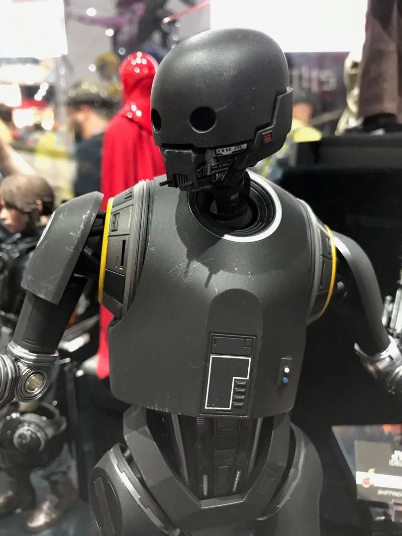 Hot Toys K-2SO close-up showing the round dark head, hollow-looking eye openings, gray chest panels and yellow shoulder markings.
