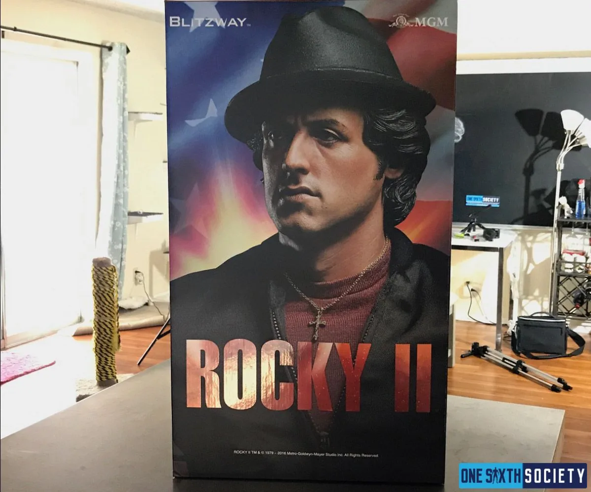Tall Blitzway Rocky II statue box on a tabletop, printed with a portrait of Rocky wearing a black hat and jacket.