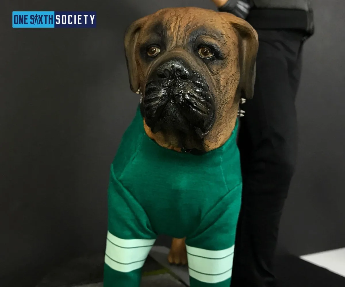 Close-up of the Butkus dog statue with a wrinkled brown face, glossy black muzzle and green jersey with white sleeve stripes.