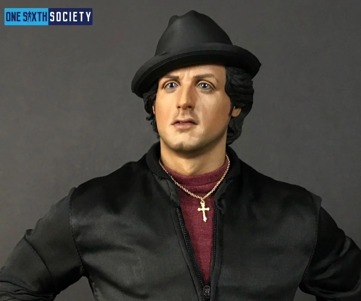 Close-up of the Blitzway Rocky statue wearing a black hat and jacket, burgundy shirt and gold cross necklace.