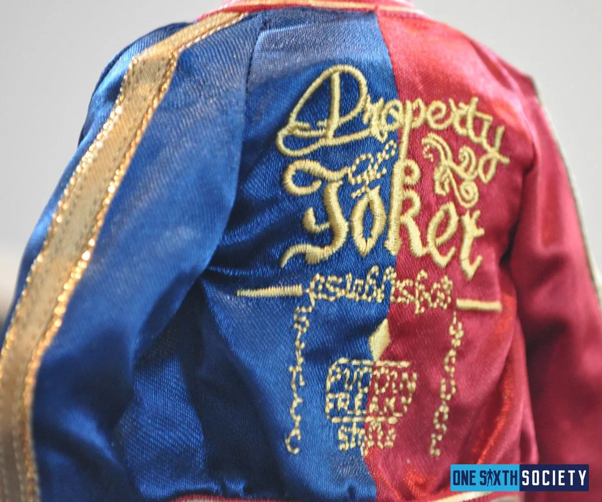 Back of Harley Quinn's red-and-blue satin jacket, showing gold Property of Joker embroidery.