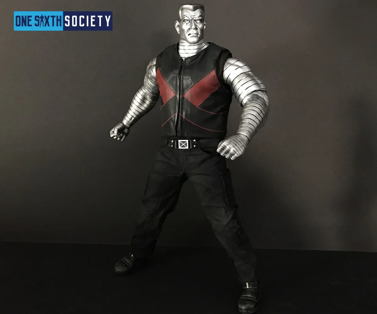 Colossus figure standing with bent arms and clenched fists, wearing a black-and-red vest above black trousers.