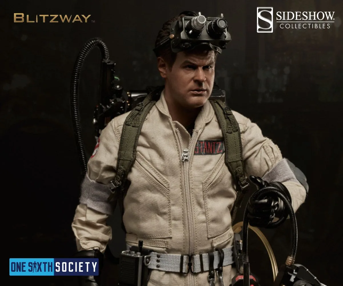 Ray Stantz figure with Ecto Goggles raised on his head, wearing a beige uniform and holding a proton-pack wand.
