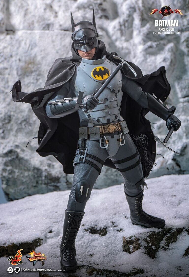 Batman in the gray Arctic Suit standing on snow with his full cowl and cape visible.