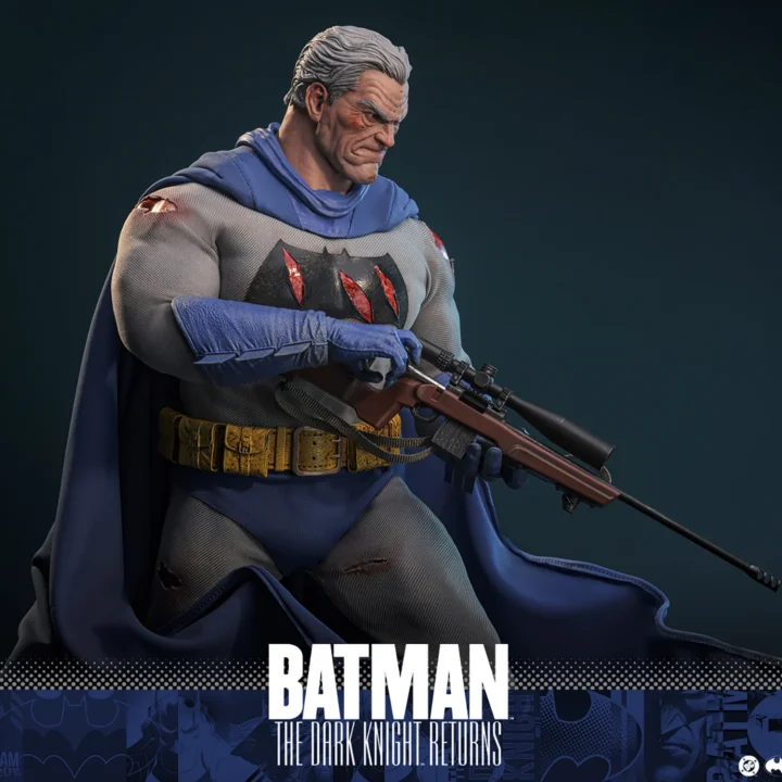 Hot Toys Batman with the unmasked gray-haired Bruce Wayne head, holding a rifle across his body as the weathered blue cape spreads around his legs.