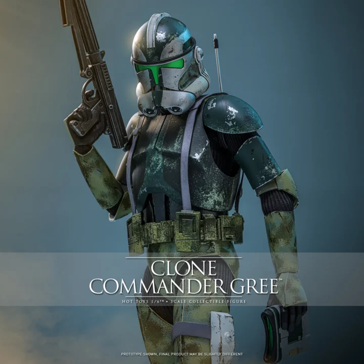 Hot Toys Clone Commander Gree holding a blaster upright beside his helmet, with a green visor, chipped camouflage armor and macrobinoculars in his lowered hand.
