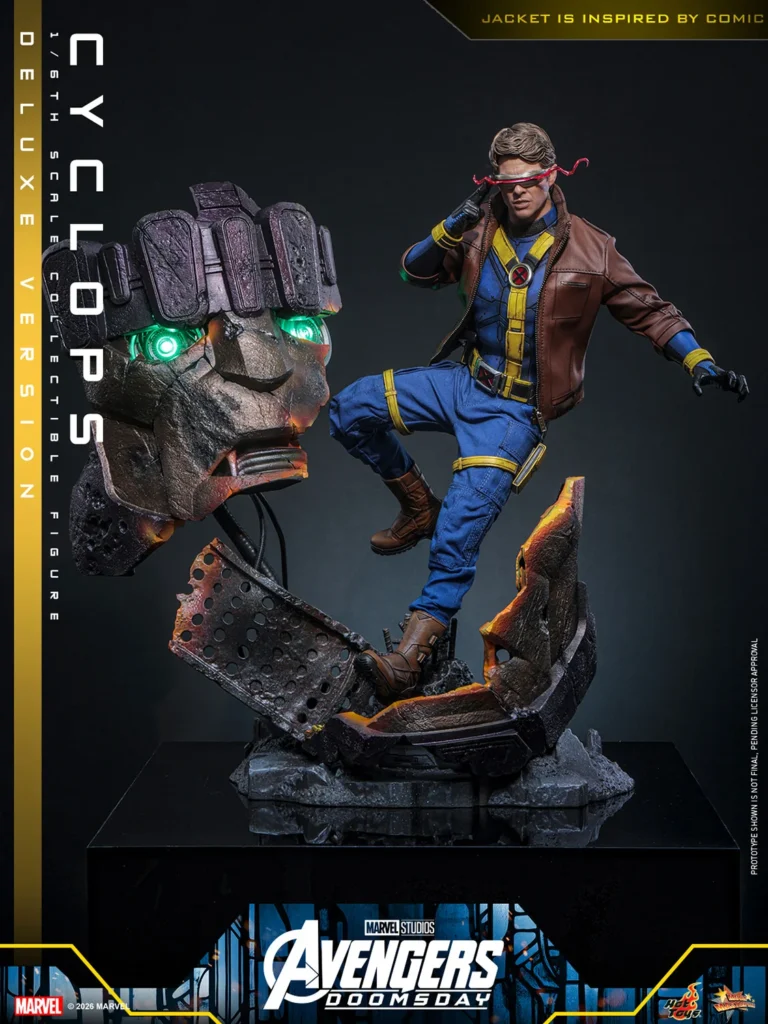 Cyclops in his brown jacket, one boot raised on the damaged Sentinel diorama and one hand at his visor, with green-lit robot eyes beside him.