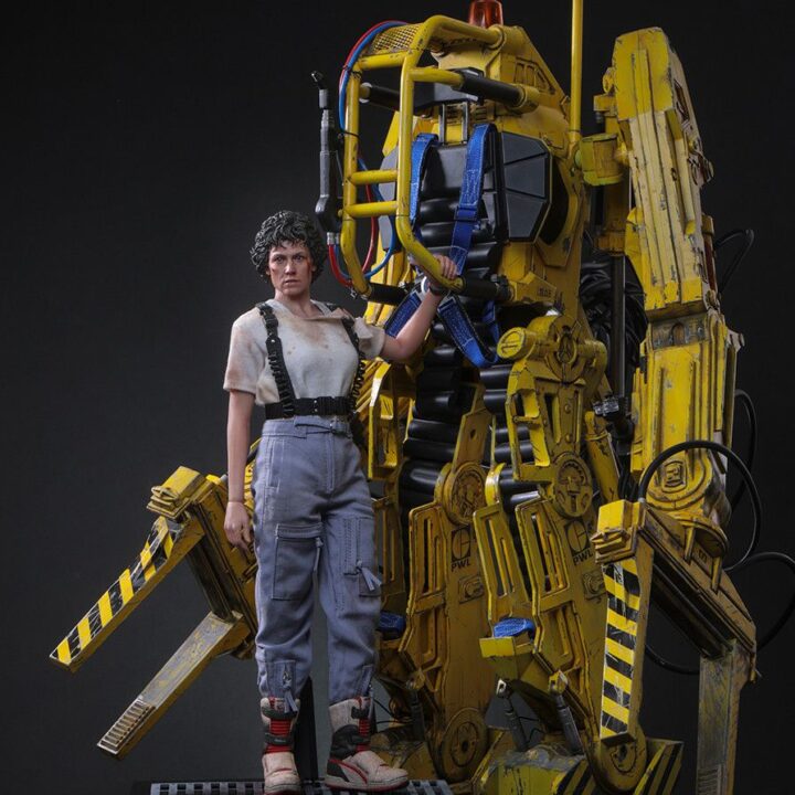 Ellen Ripley standing beside the yellow Power Loader with her separate display stand.