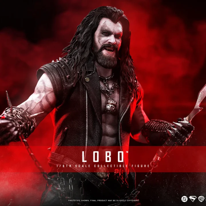 Hot Toys Lobo grinning with long black hair and a beard, holding a large metal hook and chain while wearing a spiked black vest over pale tattooed arms.