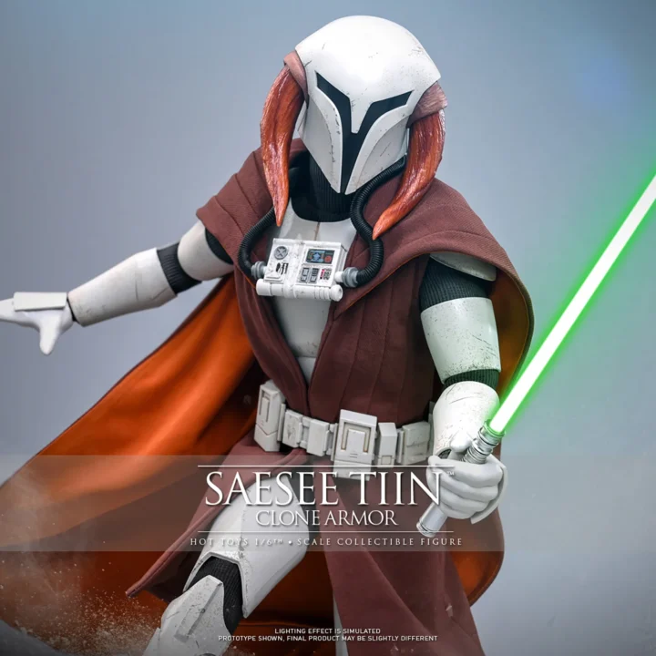Hot Toys Saesee Tiin in white Clone armor and a brown robe, extending a green lightsaber while his orange-lined cape spreads behind the helmet.