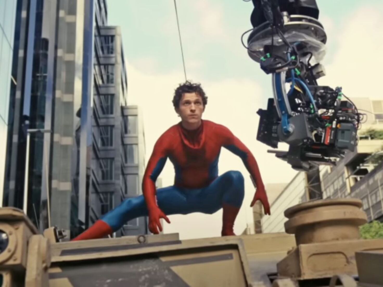 Tom Holland in his Spider-Man costume beside a camera rig on the Glasgow set