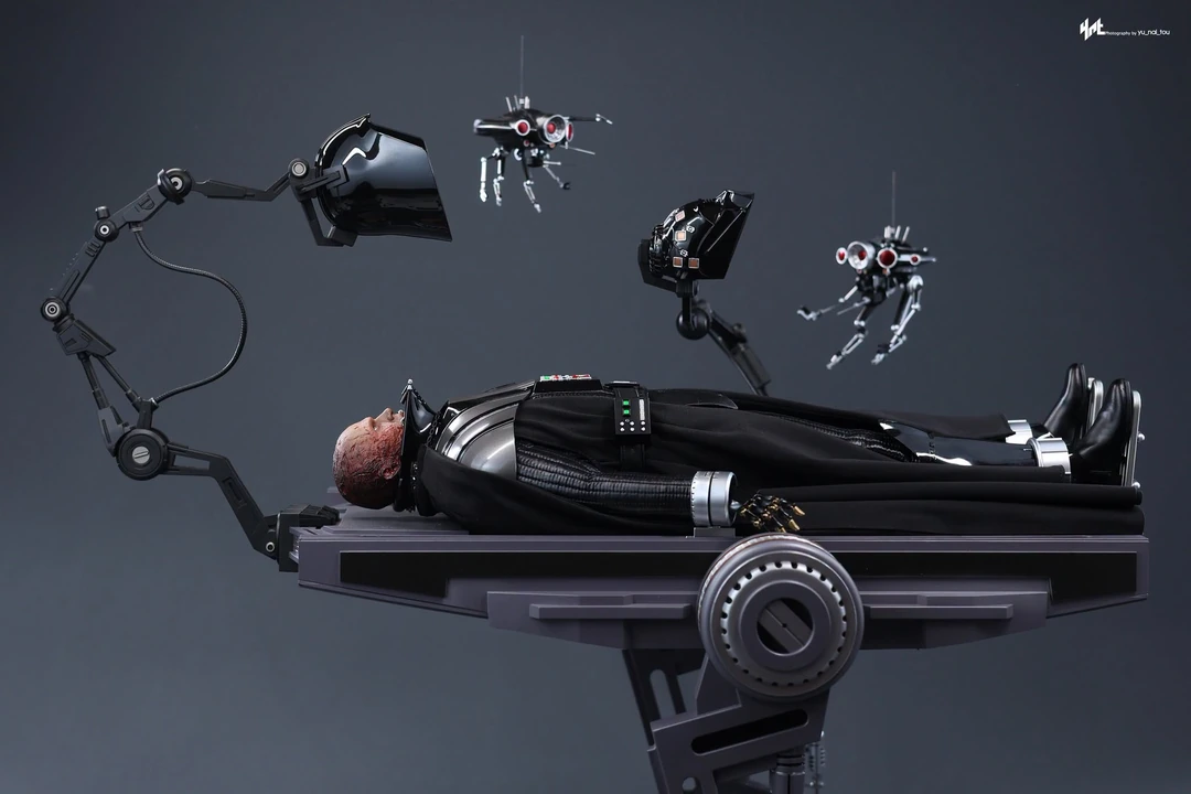 Final production review photo of Hot Toys Darth Vader Revenge of the Sith lying on the Deluxe operating table with the helmet sections held above him.